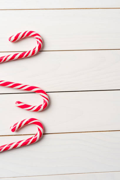 istock Candy cane on an old white wooden table 874891698