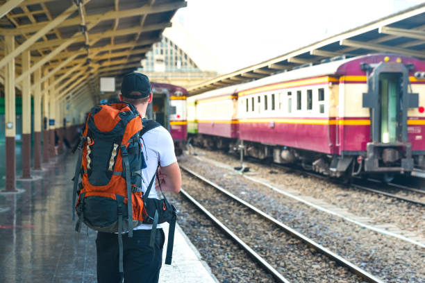 istock Man with backpack is waiting for a train in Thailand 874892106