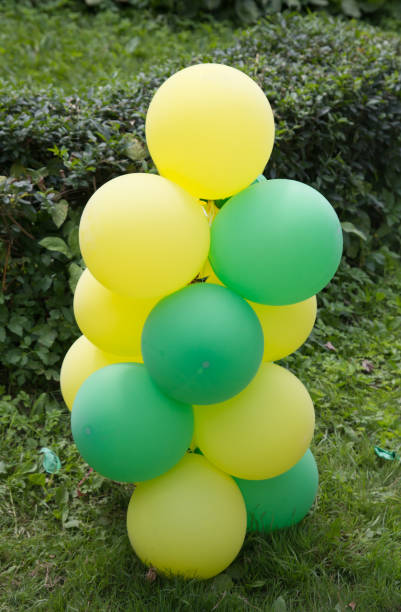 istock yellow and green balloons in nature 874892418