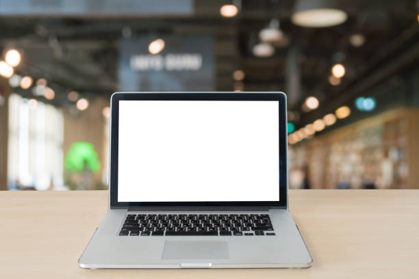 istock Mockup image of laptop with blank white screen on wooden table in modern library 874892678