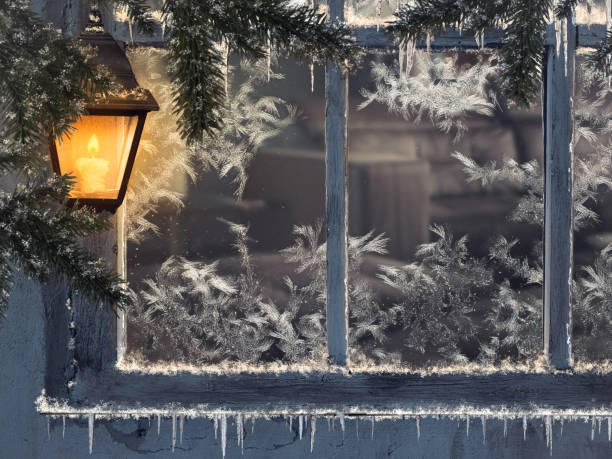 istock Beautiful winter window. Snow, icicles. Yellow lantern 874895396