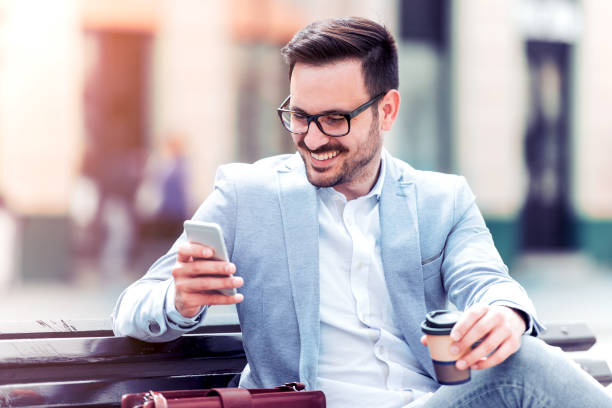 istock Young man with a phone drinking coffee to go 874898962