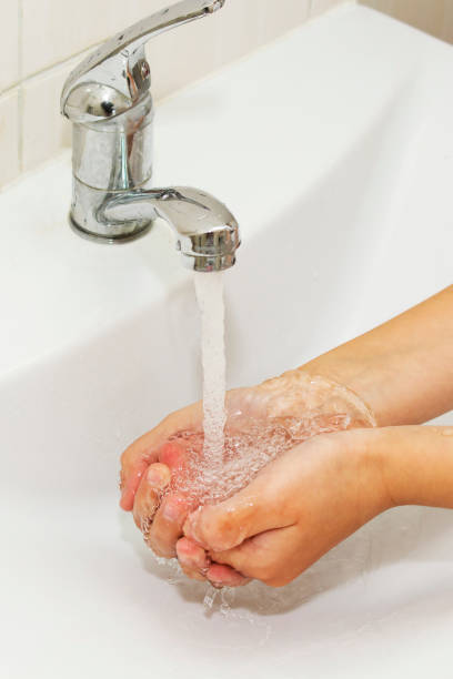 istock Washing of hands with soap under the crane with water 874907362