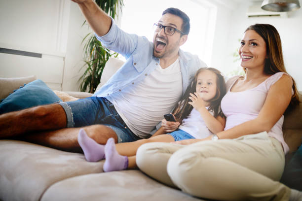 istock Happy family watching television at their home 874908270