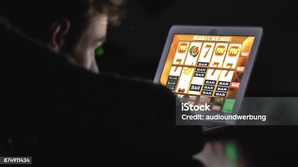 Juego Hombre Adicta Con Gafas Frente A Tragaperras De Casino En Línea En Ordenador Portátil En La Noche Foto de stock y más banco de imágenes de Internet