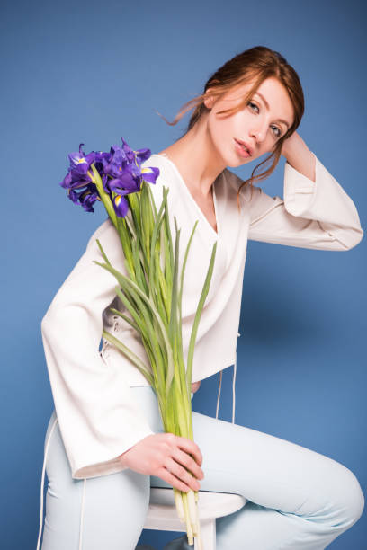 istock beautiful woman with iris flowers 874911998