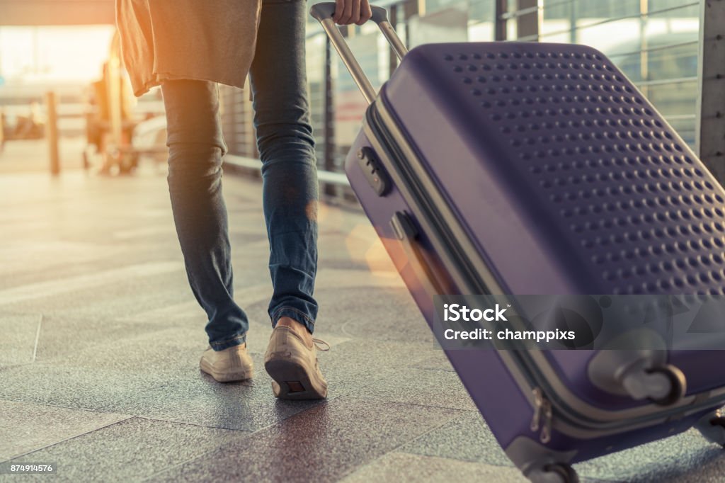 Reisende mit Koffer im Flughafenkonzept. Junge Mädchen zu Fuß mit Gepäck und Beifahrer für Tour Reise-Buchung Ticket Flug zur internationalen Urlaubszeit im Urlaub Ruhe und Entspannung. - Lizenzfrei Koffer Stock-Foto