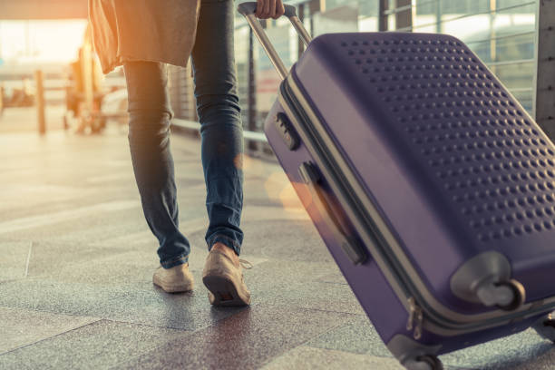 traveler with suitcase in airport concept.young girl  walking with carrying luggage and passenger for tour travel booking ticket flight at international vacation time in holiday rest and relaxation. - airport passengers imagens e fotografias de stock