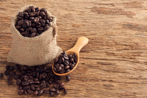istock Coffee seeds in sack on top wooden table 874917678
