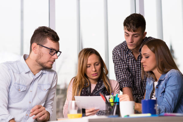 istock Young business team going through paperwork in the office 874918104