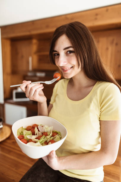 istock woman eating a vegetable 874926134