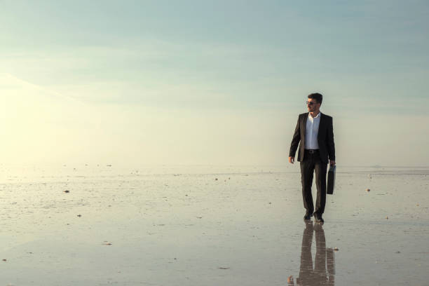 istock Man in black suit on salt lake 874927404