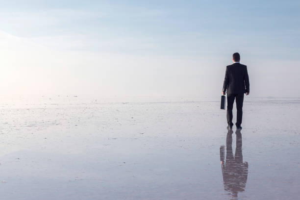 istock Man in black suit on salt lake 874927640