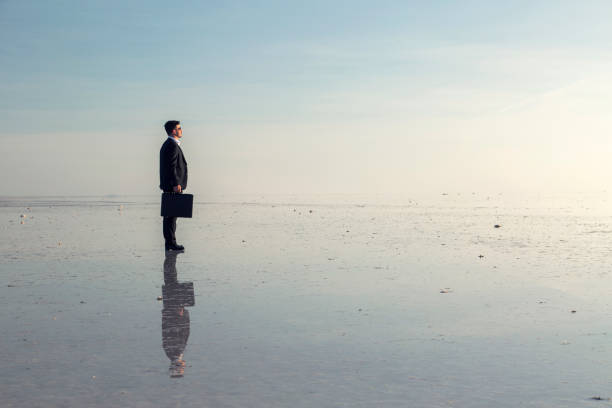 istock Man in black suit on salt lake 874927642