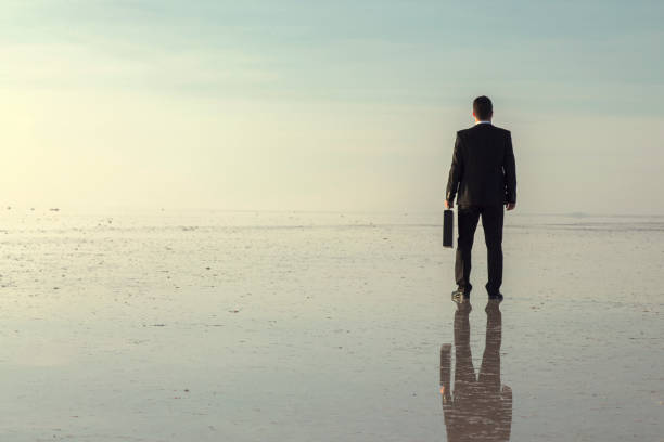 istock Man in black suit on salt lake 874927644