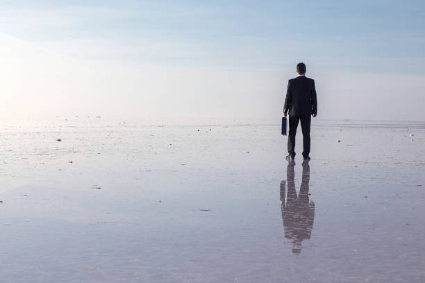istock Man in black suit on salt lake 874927648