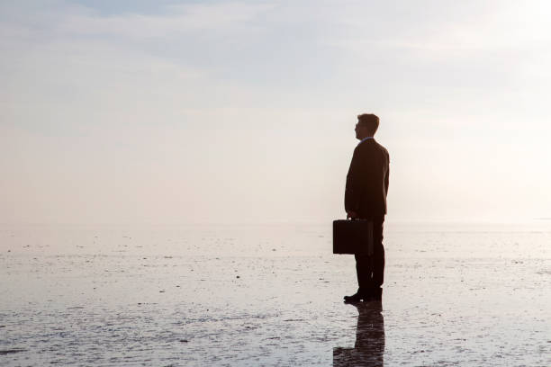 istock Man in black suit on salt lake 874927652