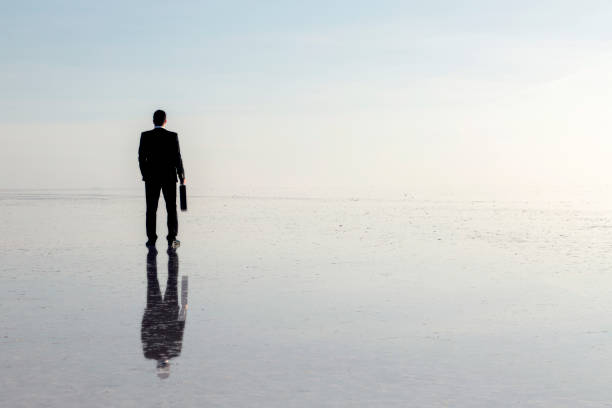 istock Man in black suit on salt lake 874927654