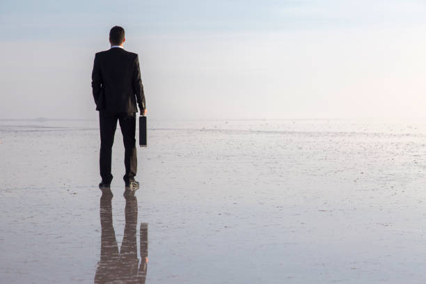 istock Man in black suit on salt lake 874927658