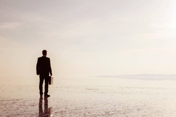 istock Man in black suit on salt lake 874927672