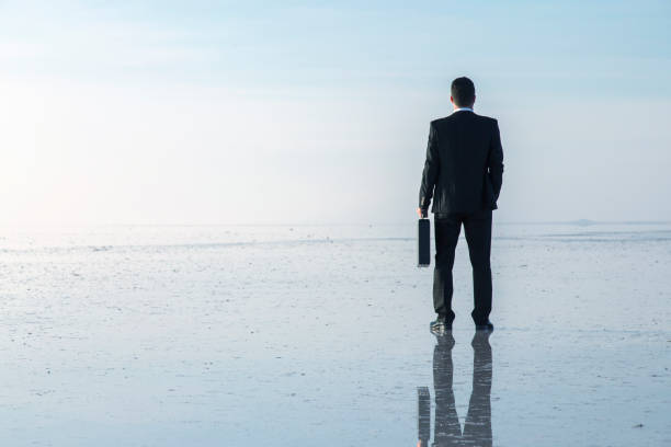 istock Man in black suit on salt lake 874927674