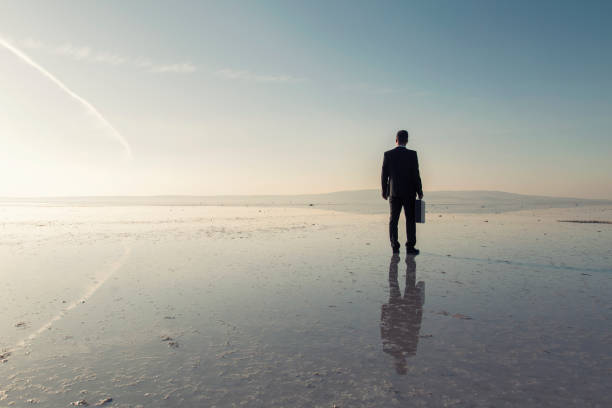 istock Man in black suit on salt lake 874927682