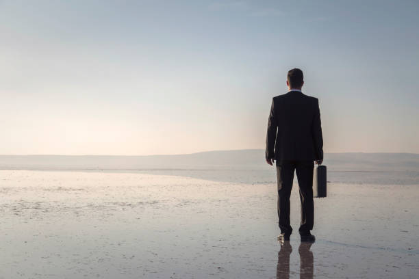 istock Man in black suit on salt lake 874927684