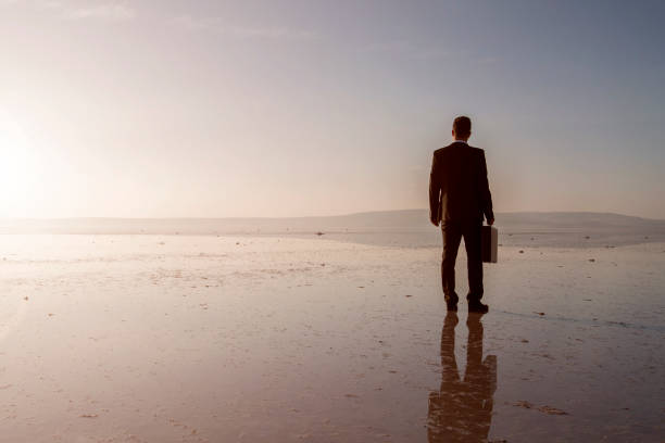 istock Man in black suit on salt lake 874927686