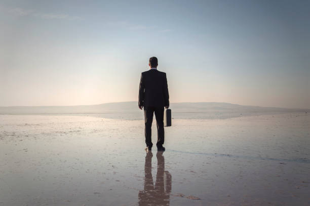 istock Man in black suit on salt lake 874927696