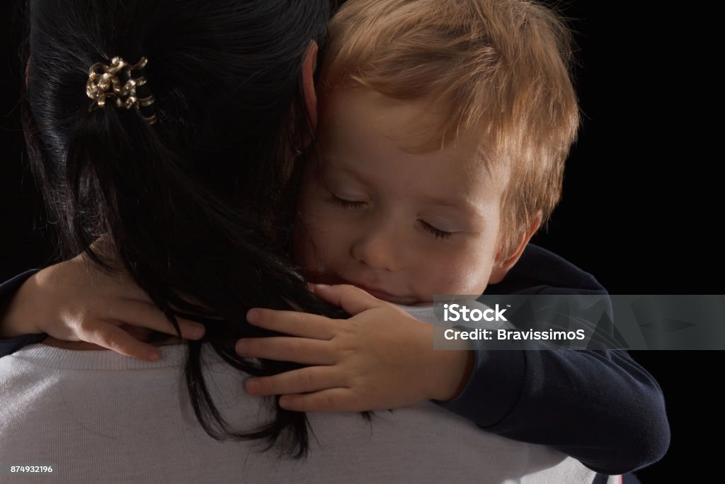 Adoption concept, an orphan is a little boy and his new mother. Happy childhood, caring for children. Adoption concept, an orphan is a little boy and his new mother. Happy childhood, caring for children. Sad boy on black background Abandoned Stock Photo