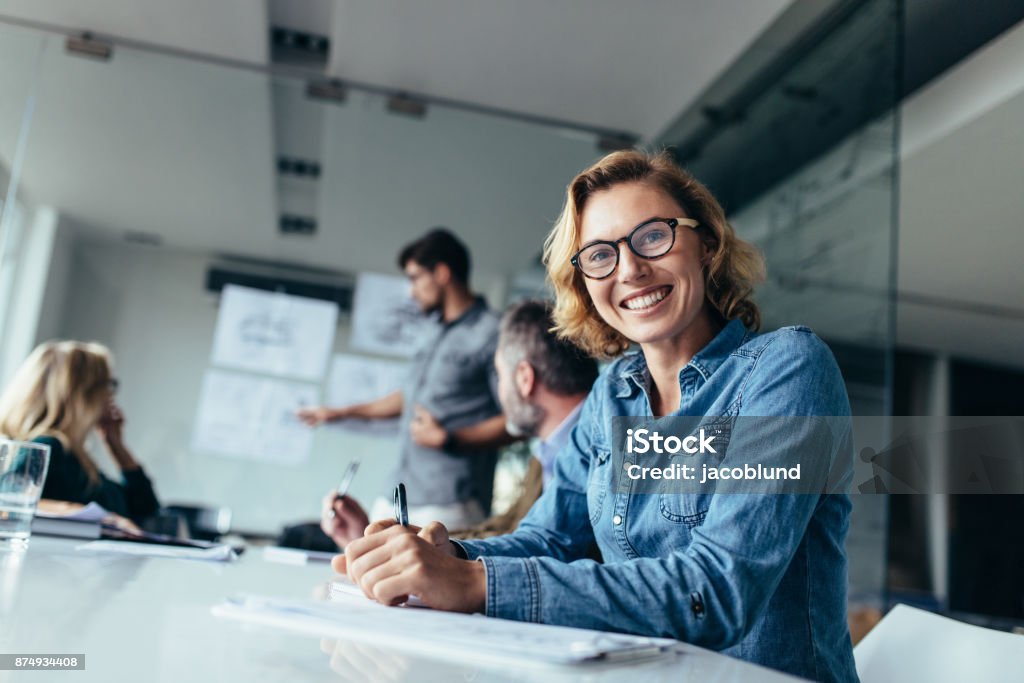 Caucasian woman sitting in board room during presentation Portrait of businesswoman sitting in conference room during presentation. Caucasian woman sitting in board room. Office Stock Photo