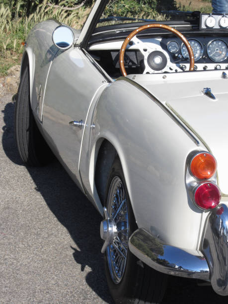istock Left side of an old british classic car . Particular view of left tail light, dashboard and shiny chrome bumper . The car is a Triumph TR3 model produced between 1955 and 1962 874940666