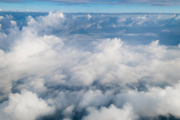 istock View from airplane window above the clouds with blue sky and cloudscape in sunlight morining. white wispy cirrus and cirrostratus clouds 874943702