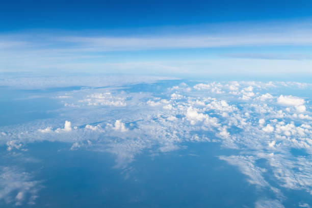 istock View from airplane window above the clouds with blue sky and cloudscape in sunlight morining. white wispy cirrus and cirrostratus clouds 874943756