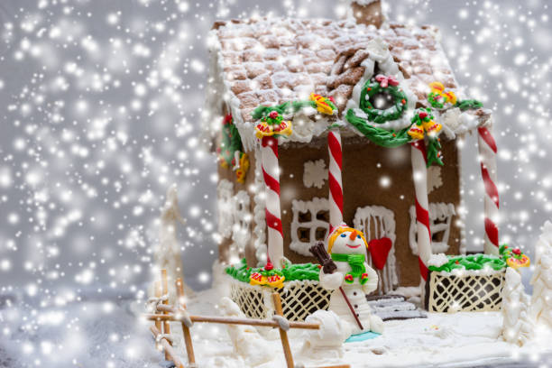 istock Gingerbread house, gingerbread Christmas tree and a sugar mastic snowman during snowfall 874951746