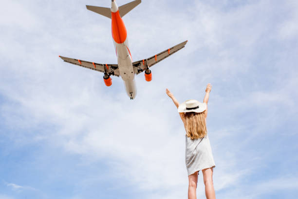 istock Woman with airplane flying on the background 874954156