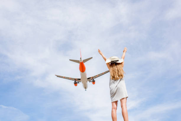 istock Woman with airplane flying on the background 874954194