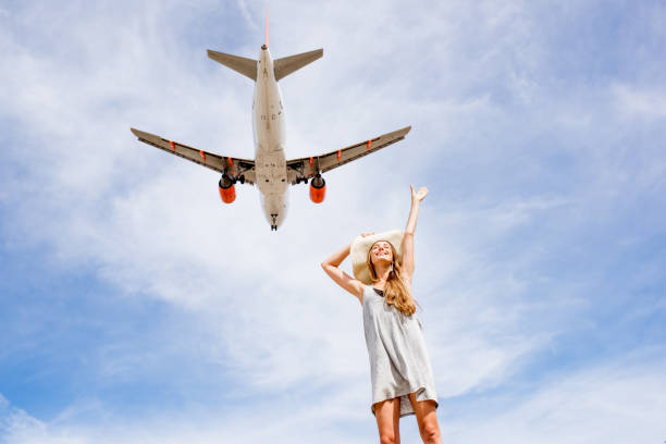 istock Woman with airplane flying on the background 874954246