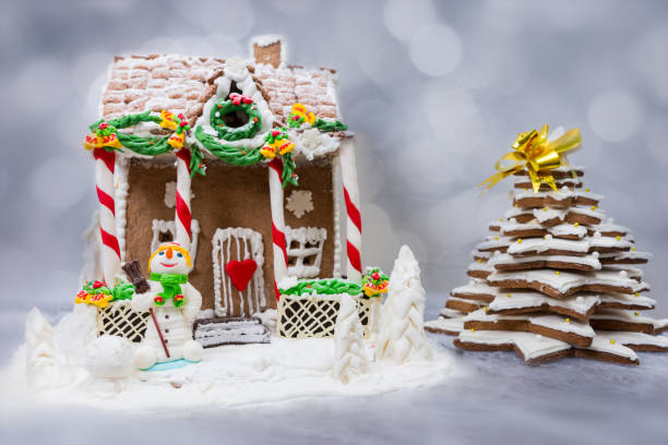 istock Gingerbread house, gingerbread Christmas tree and a sugar mastic snowman on background of defocused lights 874956244