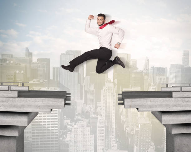 istock Energetic business man jumping over a bridge with gap 874962450