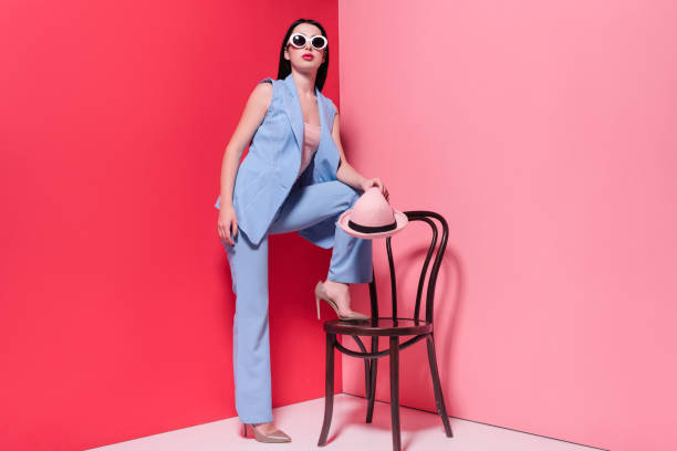 istock stylish girl posing with chair 874968026