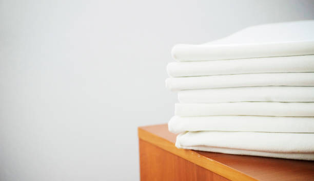 white washed ironed pile of linen on the wooden stock photo
