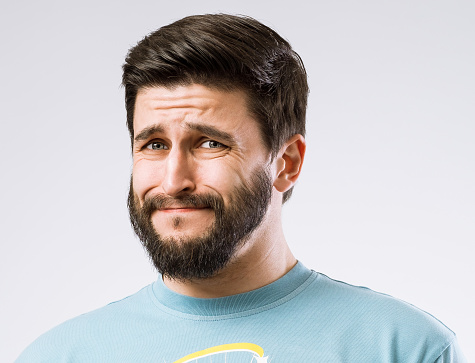 Portrait of bearded guy with disgusted expression on face