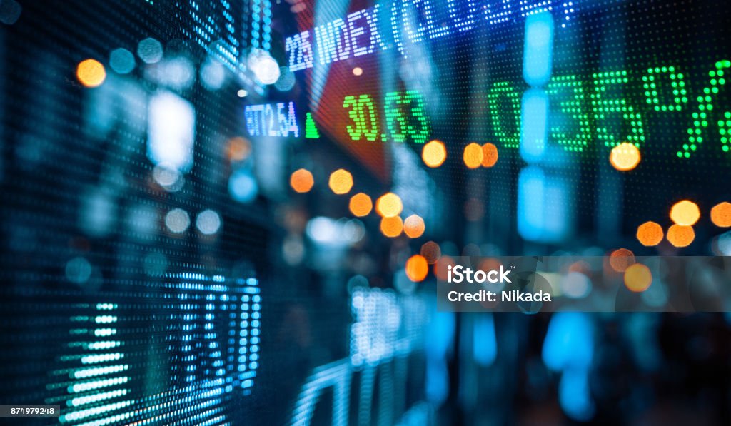 Display of Stock market quotes with city scene reflect on glass Stock Market and Exchange Stock Photo