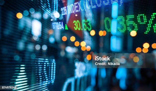 Display Of Stock Market Quotes With City Scene Reflect On Glass Stock Photo - Download Image Now