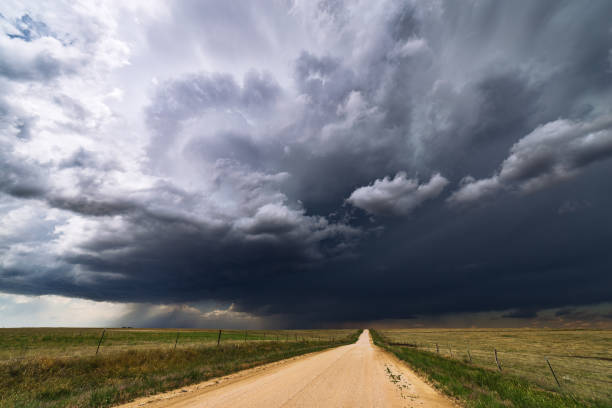 istock Stormy sky over a dirt road and field. 874979316