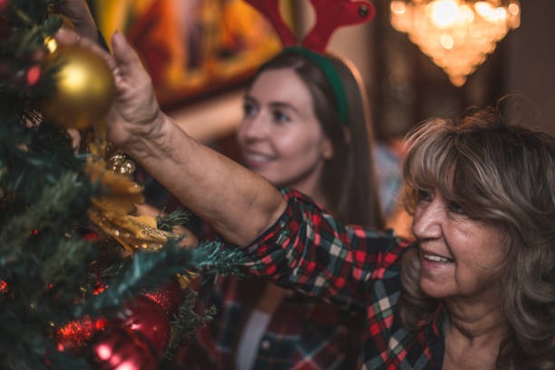 istock Grandmother decorating the christmas tree with some help 874982664