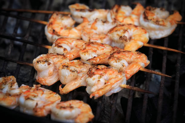 istock Large shrimps on skewers are roasting on grill 874983264