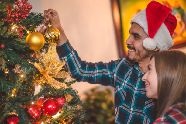 istock Happy couple decorating the crhristmas tree together 874983480