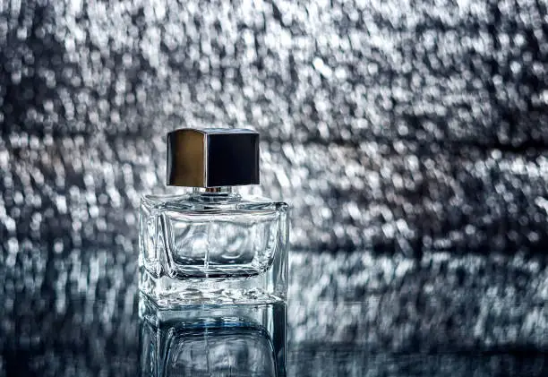 Empty bottle of perfume on an blurred background. Copy space